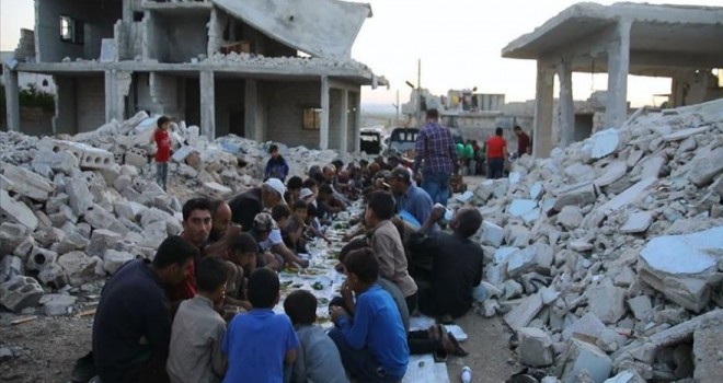 Suriye'de bombalanmış evlerin arasında toplu iftar